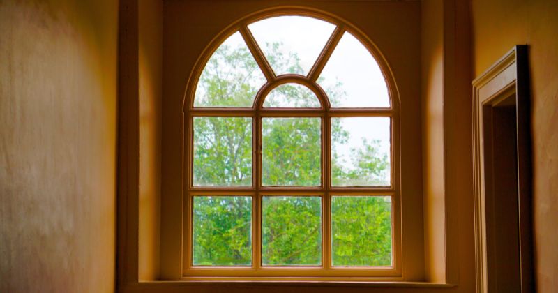 Wooden window curve with a green scenery.