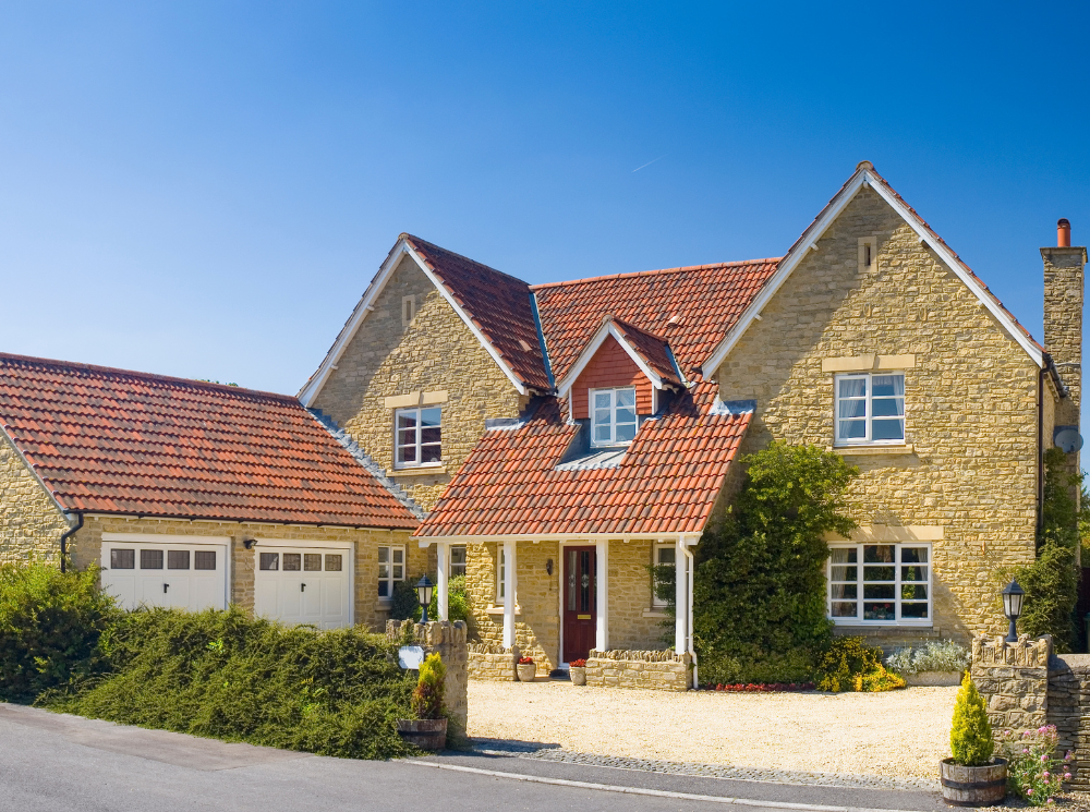 Two-story house with casement windows and red brick roof.