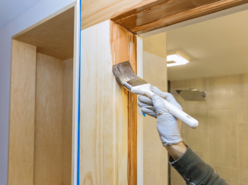 applying varnish to wooden casement window
