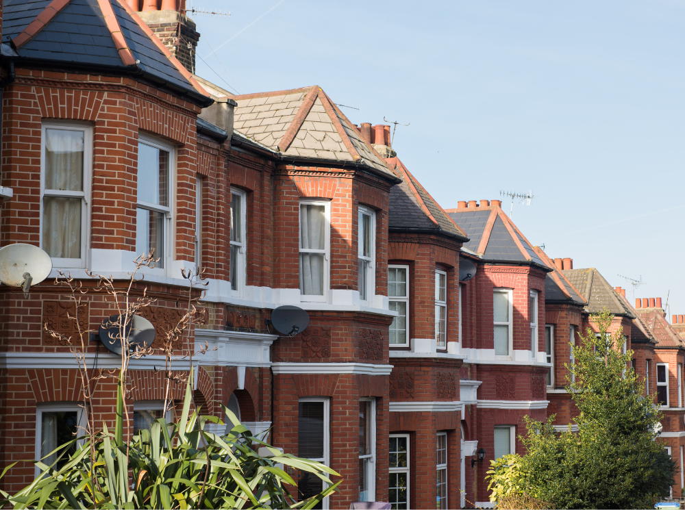 Row of medium-sized houses with white casement windows and red brick design texture