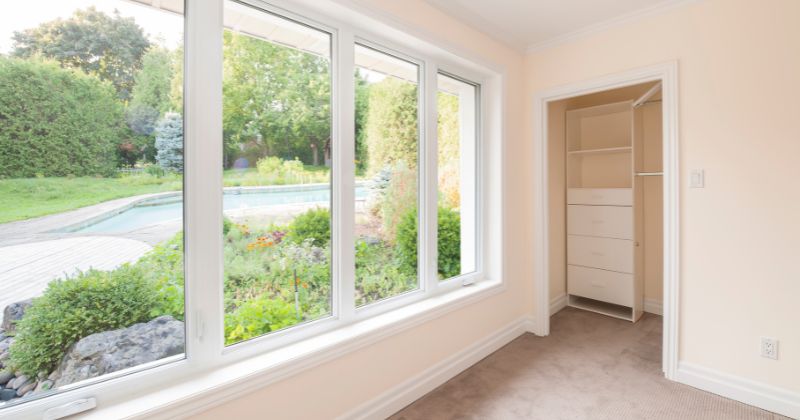 Room with large glazing windows offering scenic garden view.