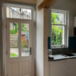 Kitchen with a replacement glass panelled door and sliding sash window