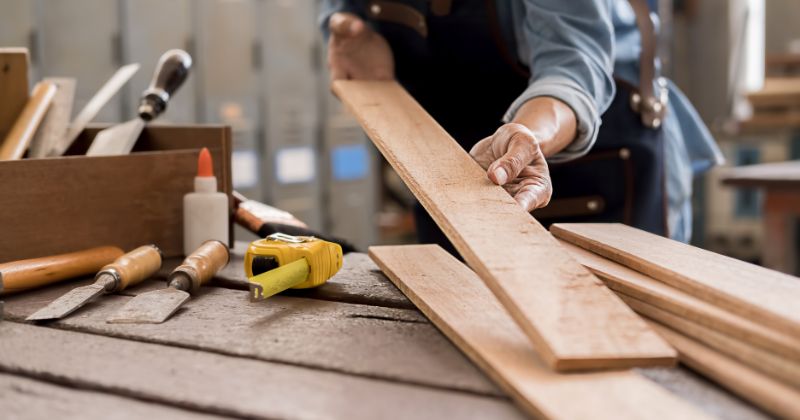 Man working on timber wood polishing for furniture.